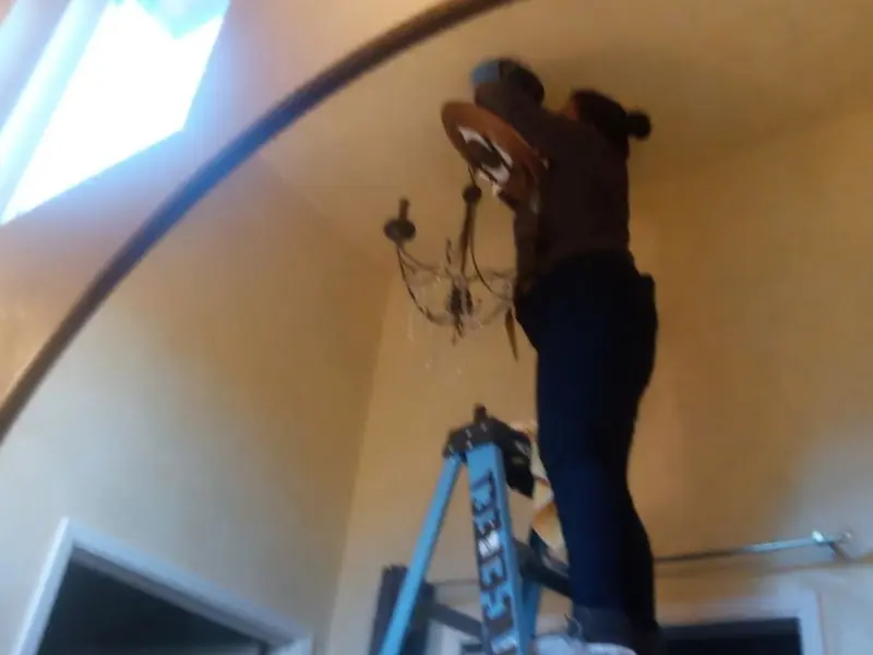 Electrician installing a chandelier in a Frackville residence